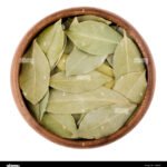 dried-bay-leaves-in-a-bowl-on-white-aromatic-leaves-of-laurus-nobilis-GJ86MB