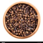 dried-cloves-in-a-wooden-bowl-on-white-background-brown-aromatic-flower-H2KGHB