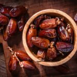Overhead view of organic dried dates in a wooden bowl